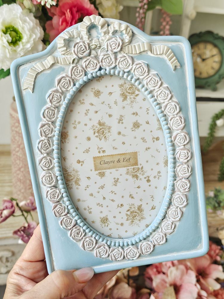 Modrý pastelový fotorámeček s růžičkami a mašlí - 14*2*21 cm / 10*15 cm Clayre & Eef Modrý pastelový fotorámeček s růžičkami a mašlí - 14*2*21 cm / 10*15 cm Clayre & Eef